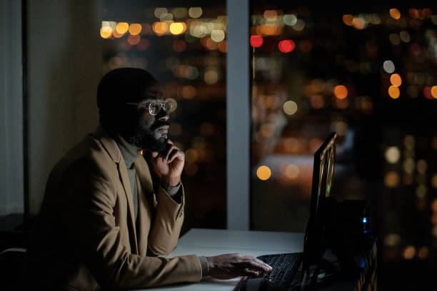 istock Young serious African businessman looking through online data 1360841089