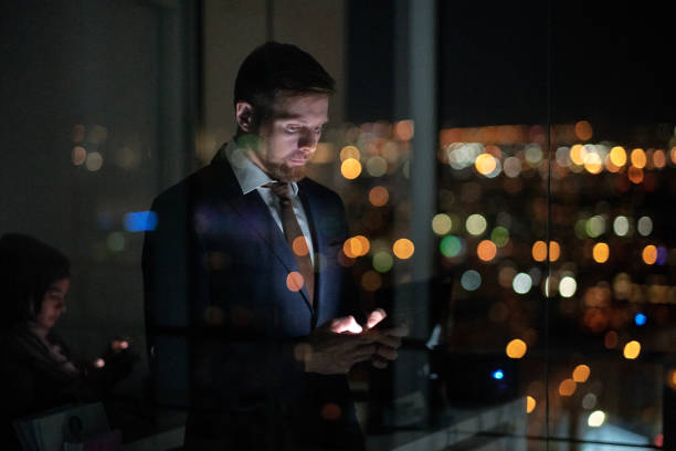 istock Young serious businessman scroling in smartphone by window 1360841096