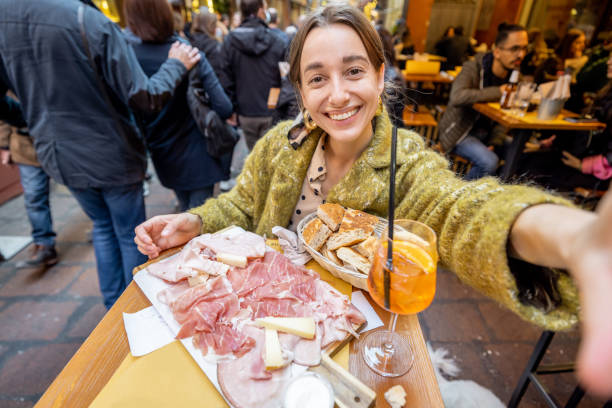 женщина с итальянской едой в баре на открытом воздухе - antipasto prosciutto italian culture ham стоковые фото и изображения