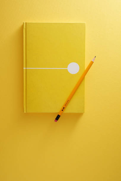 istock yellow color note pad with pencil against yellow background 1360841892