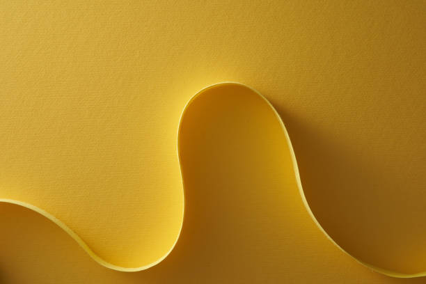 istock Curve and wave yellow paper strip on yellow background 1360841912