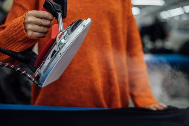 istock young woman holding steaming iron in hand 1360845807
