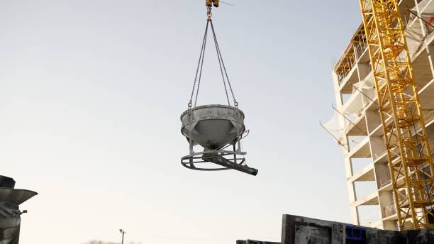 istock Construction crane over a building under construction. The crane lifts the container with liquid concrete. A tower crane lifts the solution to a multi-storey building 1360846807