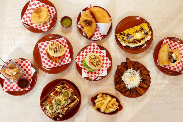 mesa con comida latinoamericana, arepas venezolanas, empanadas, platano con queso. - cultura venezolana fotografías e imágenes de stock