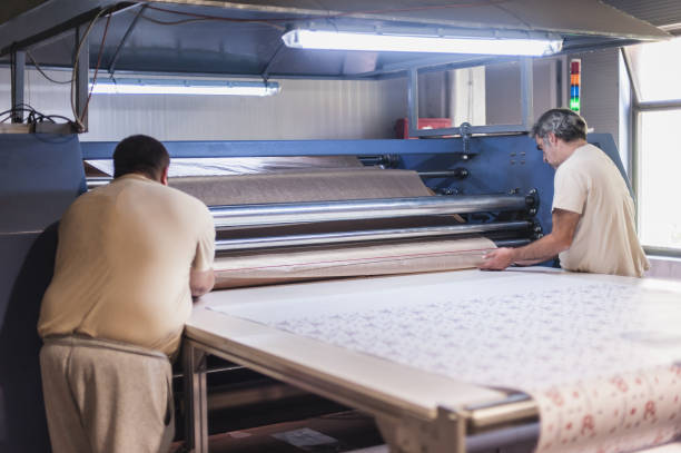 istock Technician works on large industrial textile sublimation heat printing machine 1360850410