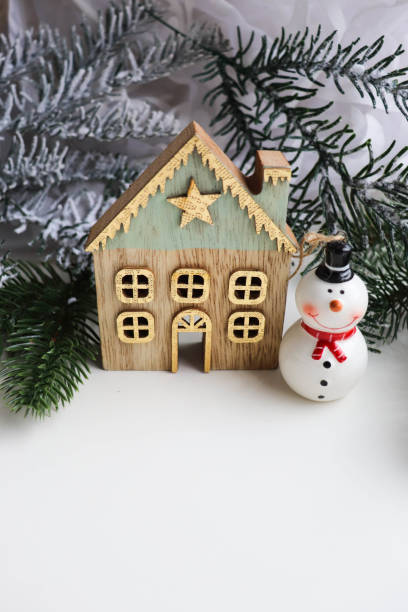 istock house, green spruce and little snowman 1360850438
