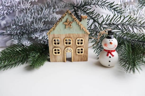 istock house, green spruce and little snowman 1360850441