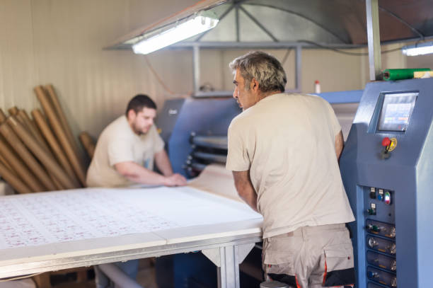 istock Technician works on large industrial textile sublimation heat printing machine 1360851102
