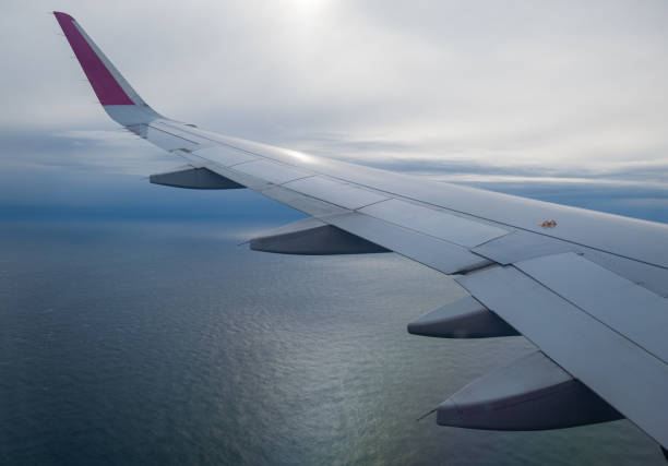 istock Aerial evening sky and clouds view above ocean from airplane porthole. 1360852029