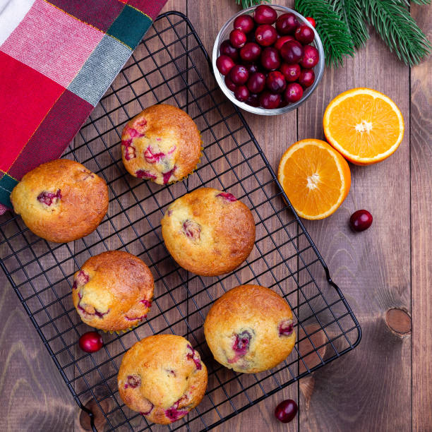 istock Cranberry orange muffins on cooling rack, square format, top view 1360852091