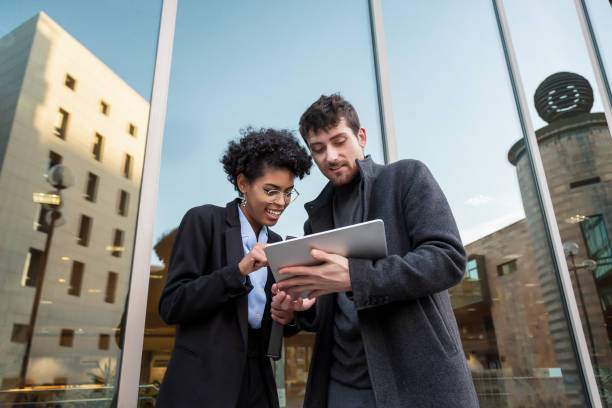 istock Business people watching a tablet and talking 1360853159