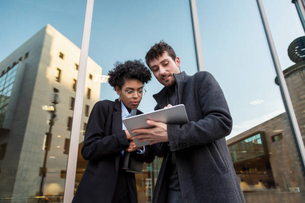 istock Business people watching a tablet and talking 1360853162