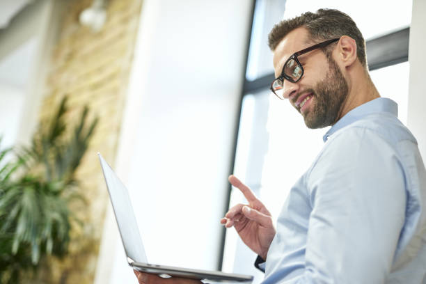 istock Cheerful office employee with modern gadget at work 1360855980