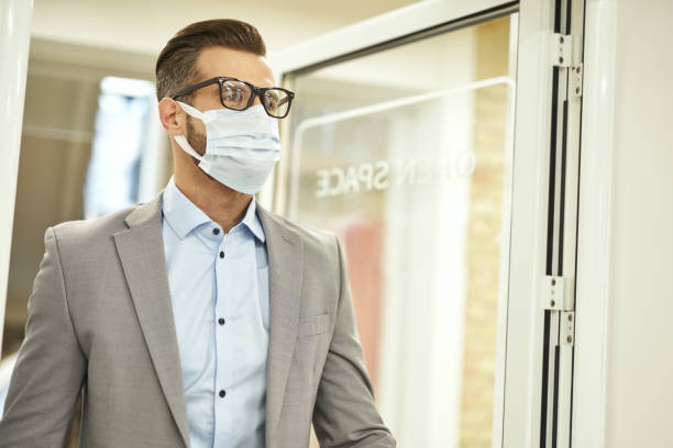 istock Elegant office manager wearing medical mask at work 1360856017