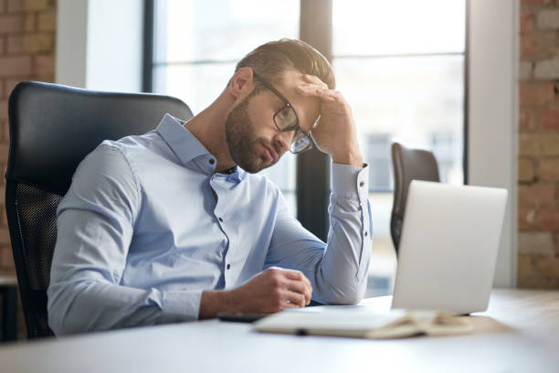 istock Tired office worker looking at the laptop screen 1360856051