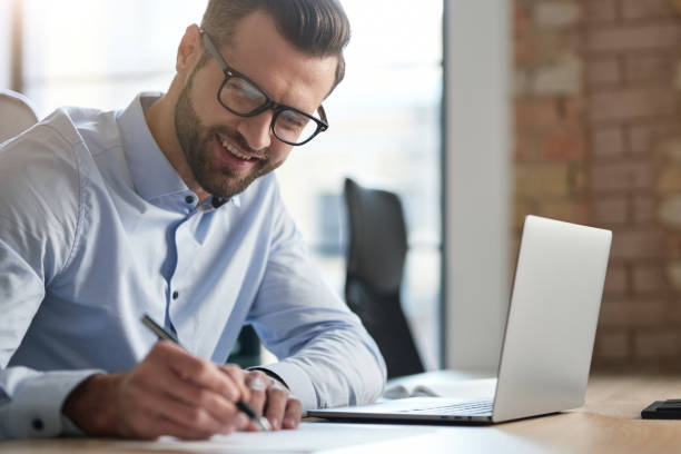 istock Contented young manager signing the documents and smiling 1360856059