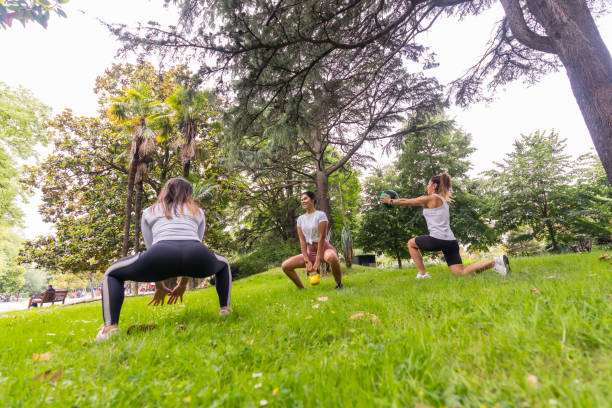 istock Latin girl doing exercise and sport in a green park, instructor teaching the students with exercises of weights and a heavy ball 1360856706