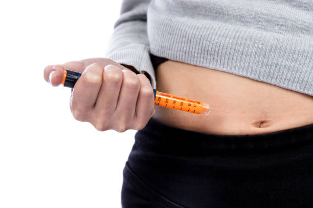 young woman injecting insulin into her belly