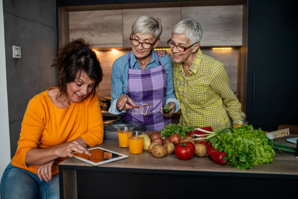 istock Three senior women preparing lunch with fresh vegetables in the kitchen 1360862011