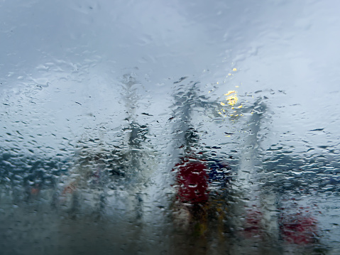 Horizontal photo of a section of a large fishing boat on the wharf at Ulladulla harbour seen through raindrops on a car windscreen.