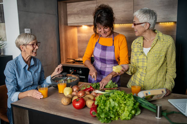 istock Three senior women preparing lunch with fresh vegetables in the kitchen 1360863298