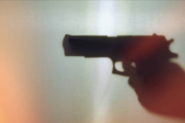 istock Hand holding a gun silhouette 1360865271