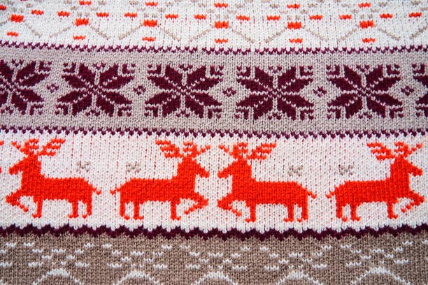 istock Jacquard knitted pattern. Geometric ornament for Christmas or New Year. Four red deer on a white knitted background, snowflakes, stripes. Winter fashionable modern animal traditional folk ornament 1360866712