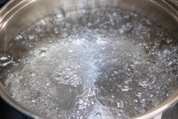 istock Water boiling violently in a metal pot 1360896780