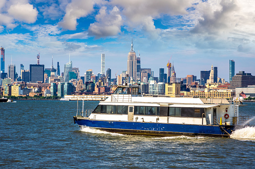 New York waterway ferry boat on the Hudson River against Manhattan cityscape background, USA
