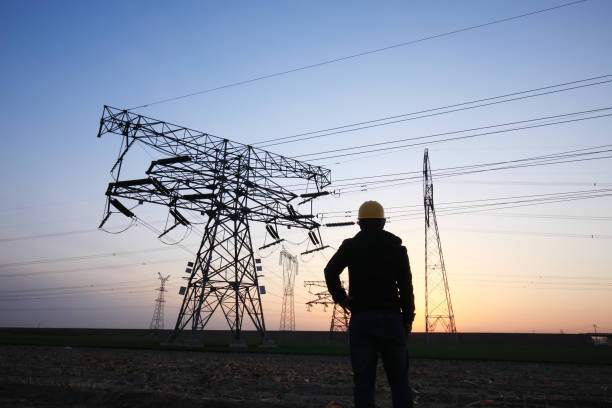 istock In the evening, electricity workers and pylon silhouette 1360898948
