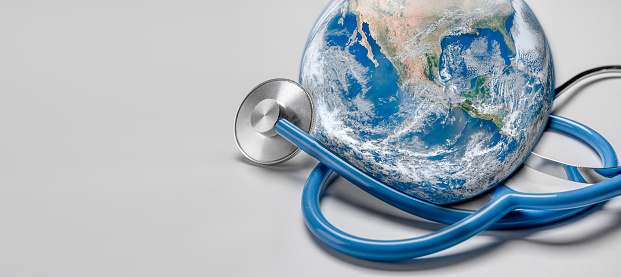 Global human health in context of coronavirus pandemic. Stethoscope wrapped around globe Earth on white background. Global health,Green Earth day concept. Elements of this image were furnished by NASA