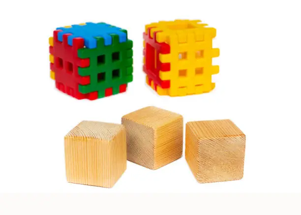 three natural wooden toy blocks and plastic puzzle pieces isolated on white background