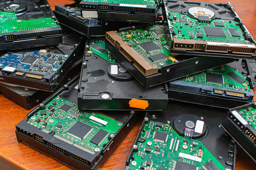 A pile of dusty broken and obsolete hard drives for disposal and recycling. Electronic data warehouse