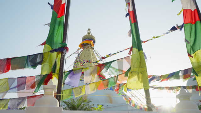 Multicolor prayer flags flutter near golden white festive Swayambhunath stupa