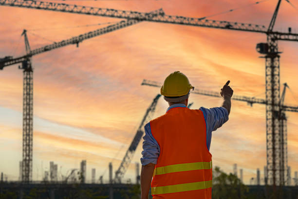 istock Asian Engineer or Investor and Worker working at Industrial Building  Real Estate project site.Team of Specialists Inspect Commercial, Project with large building. In the Background Crane Skyscraper.