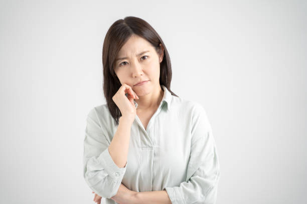 woman with an embarrassed look, white studio shot background - estereótipo de dona de casa imagens e fotografias de stock