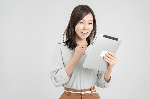 Asian woman operating tablet, white studio shot background