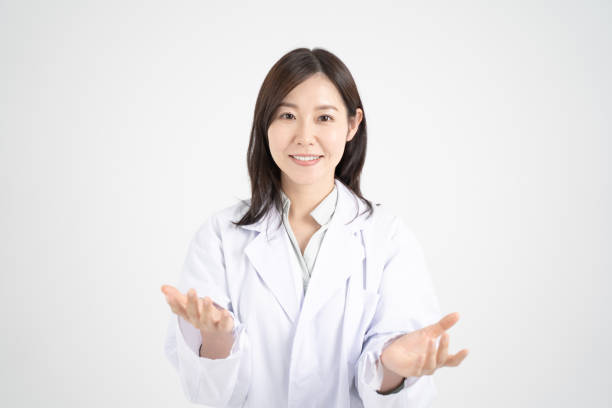 Image of a female doctor explaining online medical treatment through a computer screen White background Image of a female doctor explaining online medical treatment through a computer screen White background one mid adult woman only stock pictures, royalty-free photos & images