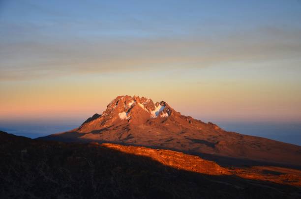 Mount Mawenzi gleams in the last rays of the sun. sunset at kilimanjaro. Trekking on the highest mountain in Africa Mount Mawenzi gleams in the last rays of the sun. sunset at kilimanjaro. Trekking on the highest mountain in Africa mawenzi stock pictures, royalty-free photos & images