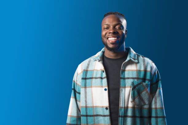 istock Handsome black man smiling. Mid shot. Blue background 1360924971