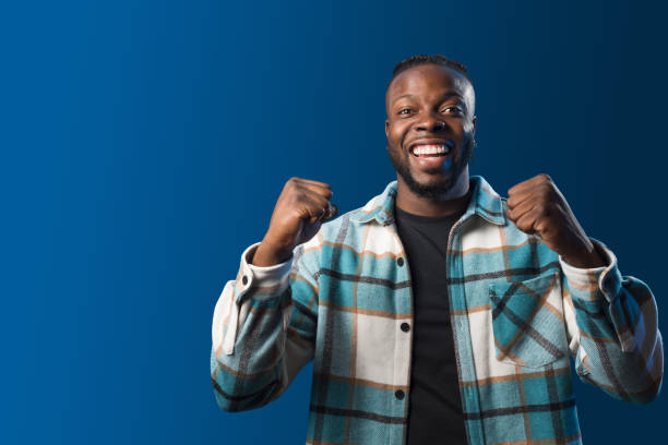 istock Handsome black man smiling, celebrating something. Blue background 1360924984