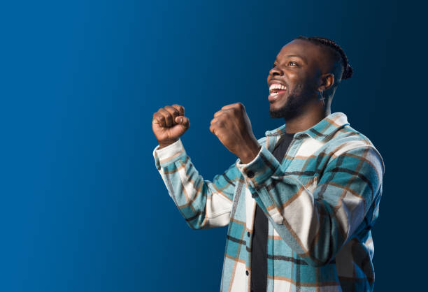istock Handsome black man smiling, celebrating something. Blue background 1360924989