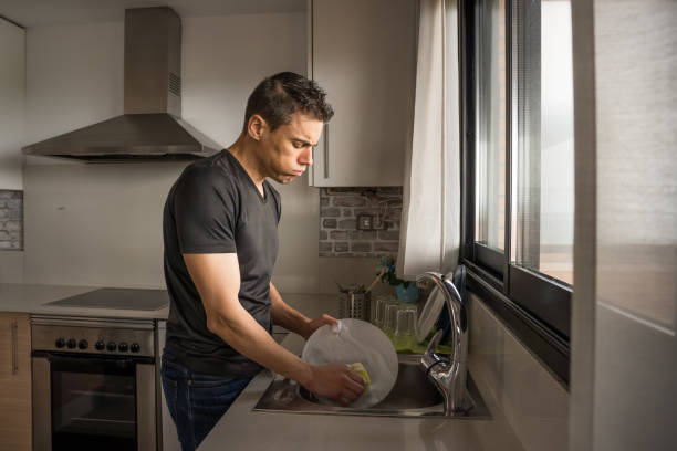 istock Man washing dishes in the kitchen. Medium shot. 1360927981