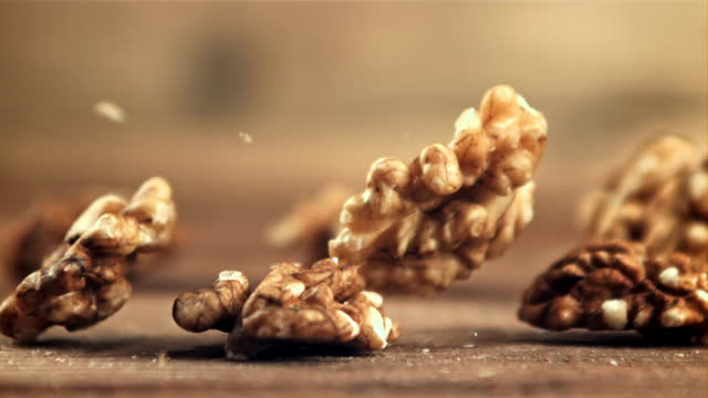Peeled walnuts fall on the table. Filmed is slow motion 1000 fps.