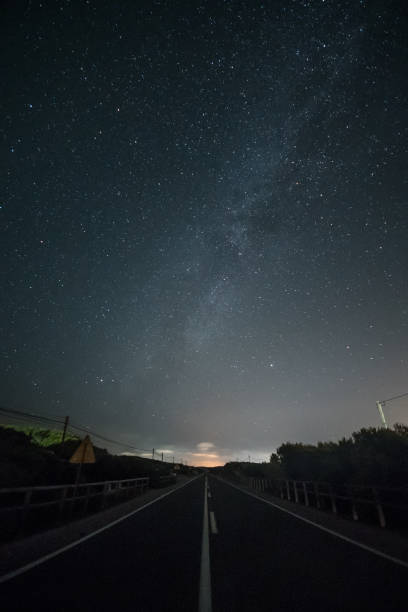 istock Night landscape with deserted road and starry sky. 1360933078