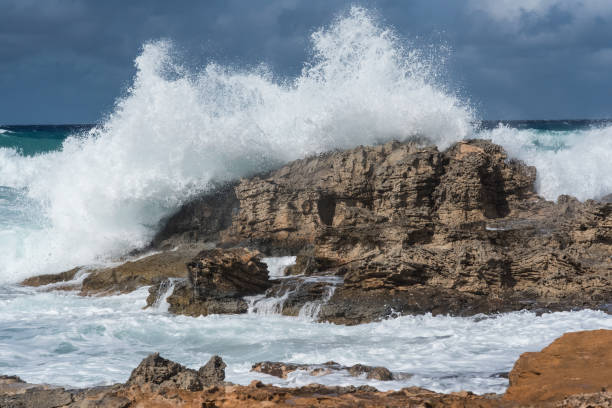 istock Rough sea day with waves crashing violently against the rocks. 1360933108