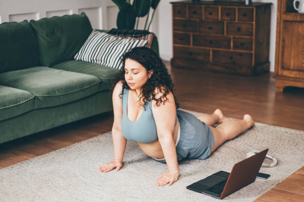 Plus size woman doing yoga and meditation at home. Plus size woman doing yoga and meditation at home. plus size photos stock pictures, royalty-free photos & images