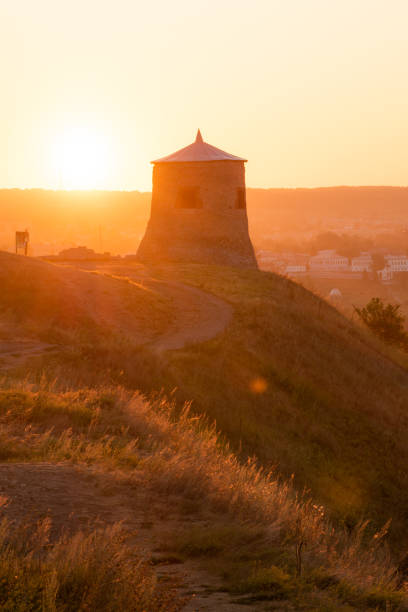 istock Ancient medieval lookout tower lit by golden light on a hill at dawn 1360934338