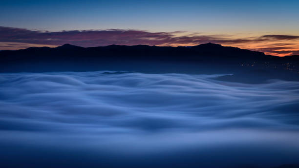 Creu de Sant Miquel Vewpoint, in Montserrat, at night, with a night sea of clouds - fog (Barcelona, Catalonia, Spain) stock photo
