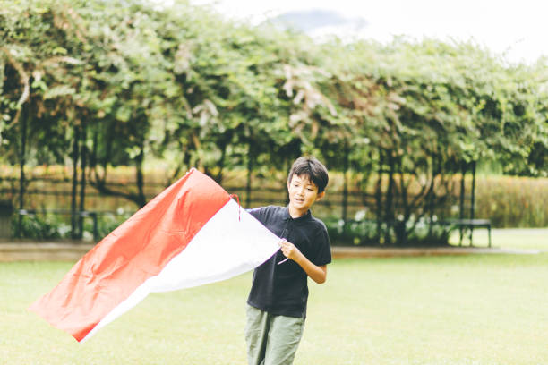 istock Little boy running with Indonesia flag at daylight 1360940087
